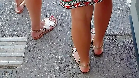 Beautiful Legs And Feet In Sandals Of Two Attractive Young Women